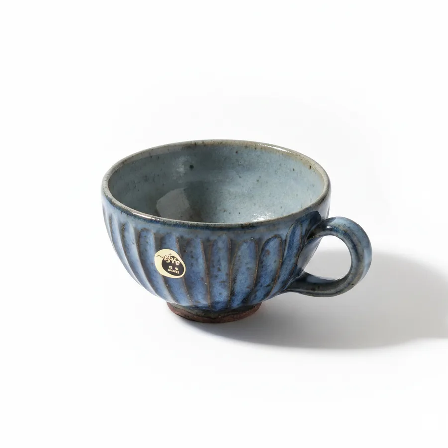 Handcrafted underglaze ceramic coffee mug on a rustic table